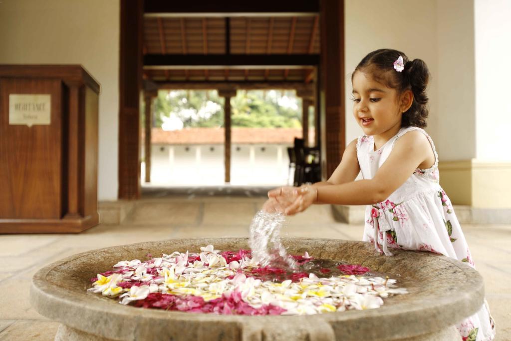 Heritage Madurai Exteriér fotografie A girl playing with flowers
